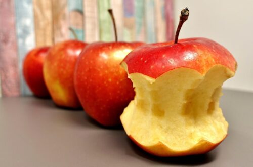 Apples in a row with first apple eaten to the core.