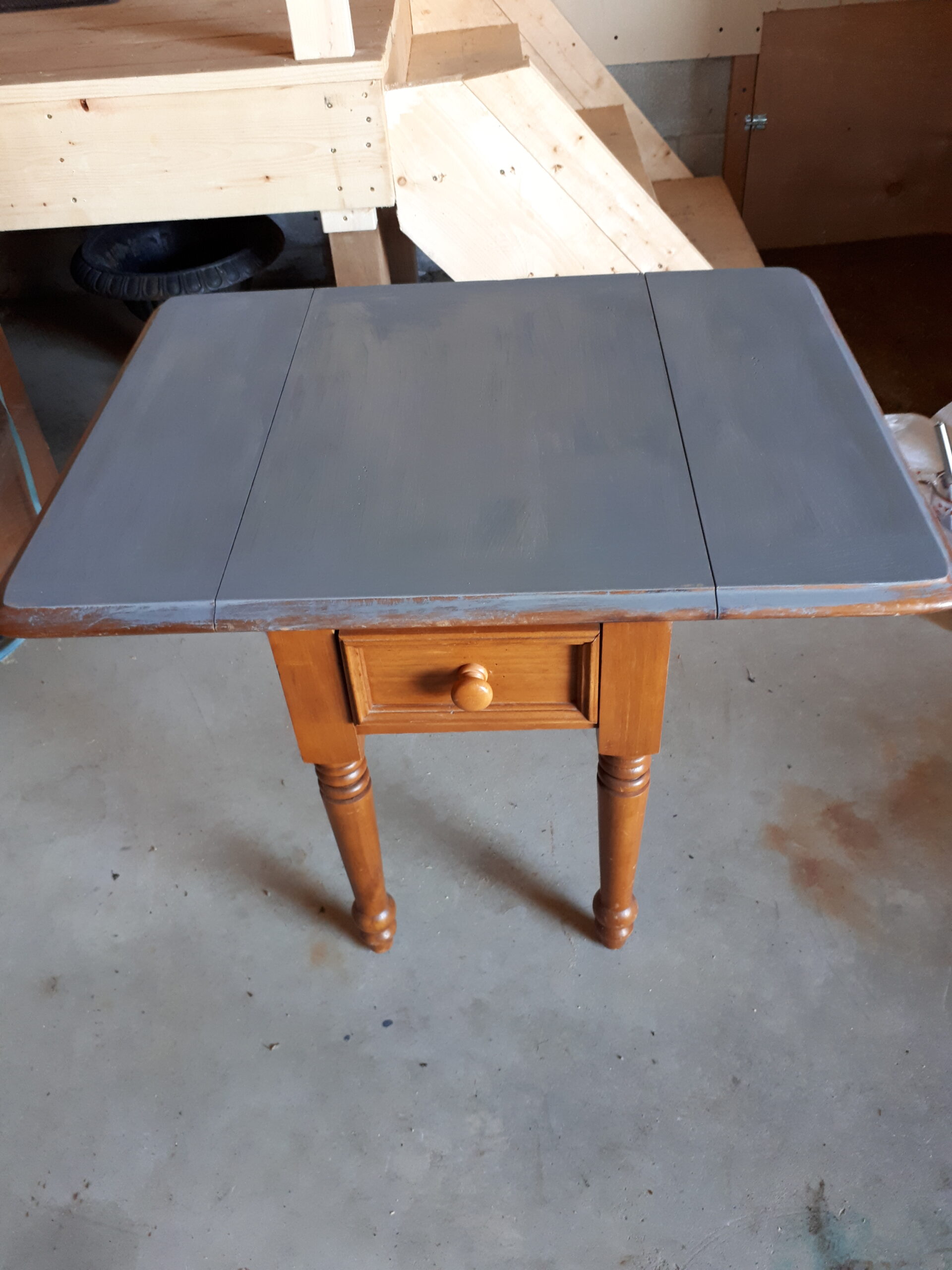Raised drop leaf on side table. Partially painted with milk paint.