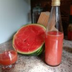 Melon and bottlw of juice made from Watermelon, lemon. ginger, and pineapple