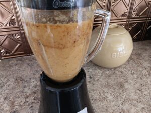 Blended pineapple and dates in a blender on a kitchen counter.