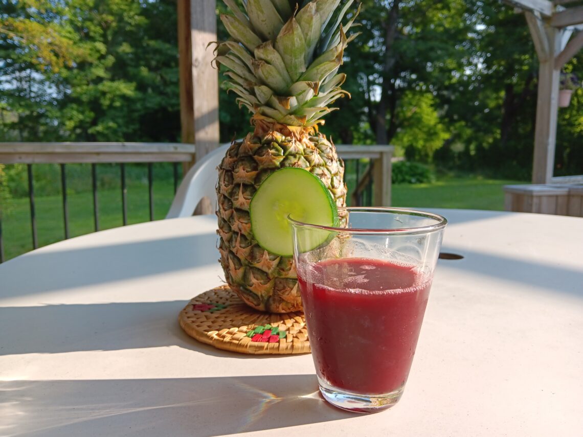 Glass of Zobo with a pineapple al fresco.