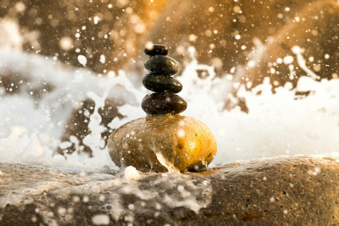 Stacked Pebbles splashed with water, bathed in natural light.